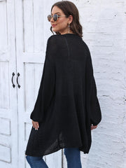 Black cable knit cocoon cardigan with balloon sleeves and open knit hem.