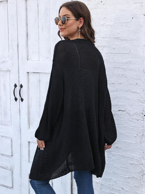 Black cable knit cocoon cardigan with balloon sleeves and open knit hem.