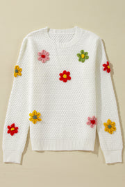 White knit sweater with crochet floral embellishments and a diamond pattern texture.