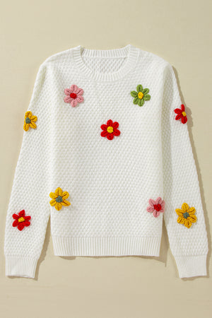 White knit sweater with crochet floral embellishments and a diamond pattern texture.