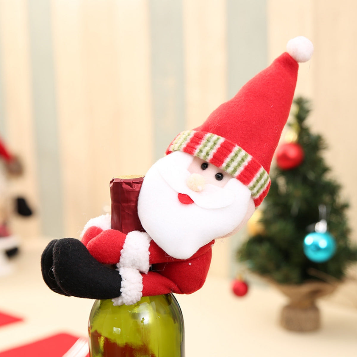 Festive Santa bottle hugger decoration in red with striped hat band and white beard.
