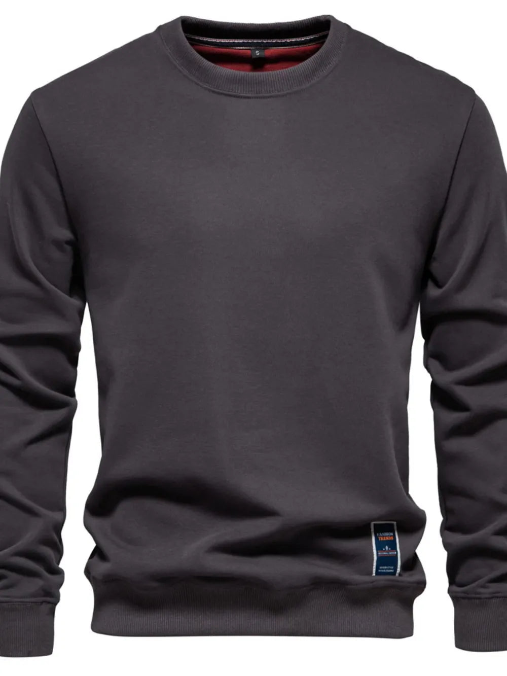 Gray crewneck sweatshirt with subtle patch detail on hem