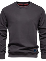 Gray crewneck sweatshirt with subtle patch detail on hem