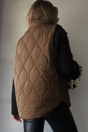 Quilted stand-collar gilet in taupe with a unique wave pattern.