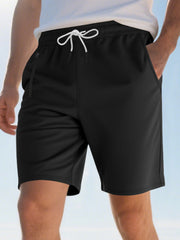 Black chino shorts with drawstring waist and zippered pocket detail.