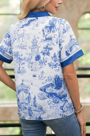 Women's blue and white toile print short sleeve shirt with blue trim.