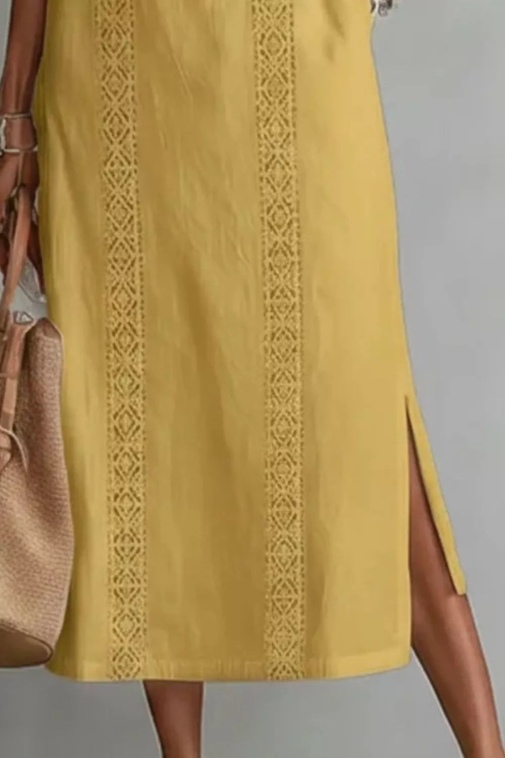 Elegant midi dress in gold with lace insets and side slits.