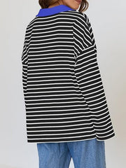 Oversized black and white striped long-sleeve sweatshirt with a blue collar.