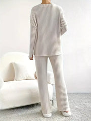 Off-white ribbed knit loungewear set with long sleeves and flared pants.