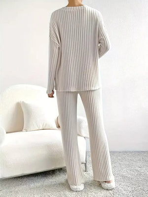 Off-white ribbed knit loungewear set with long sleeves and flared pants.