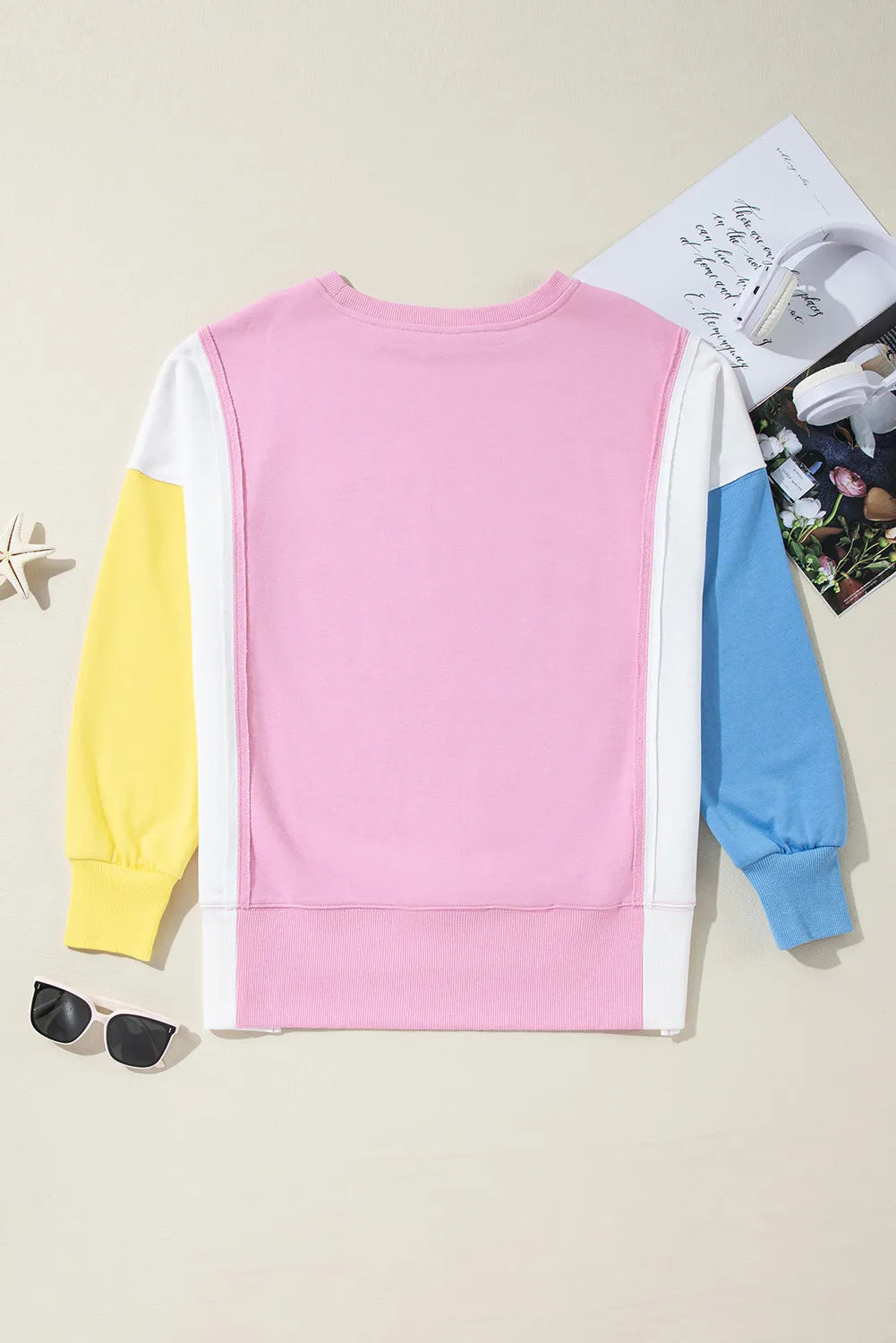 Colorblock sweatshirt in pink, white, yellow, and blue with crewneck and long sleeves.