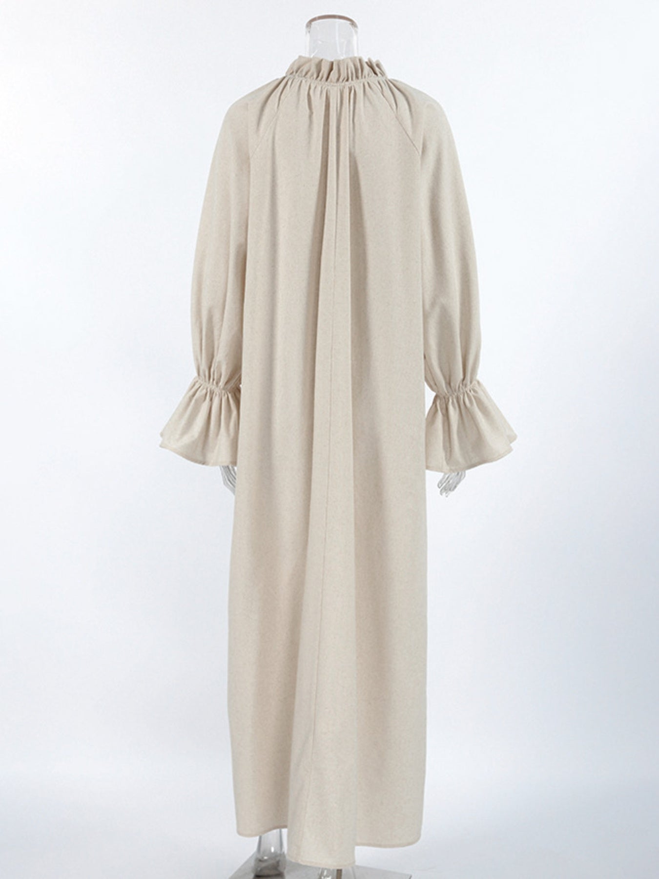 Beige cotton maxi dress with tie neck, ruffled collar, and ruffled cuffs.