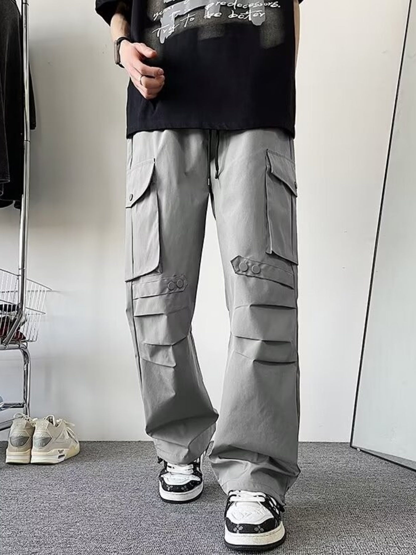 Light gray wide-leg cargo pants with multiple flap pockets and button details.