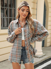 Plaid collared long sleeve shirt in gray with orange and white plaid, featuring button-down front and chest pockets.
