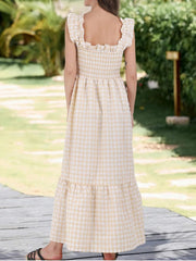 Apricot gingham midi dress with smocked bodice and ruffled sleeves.