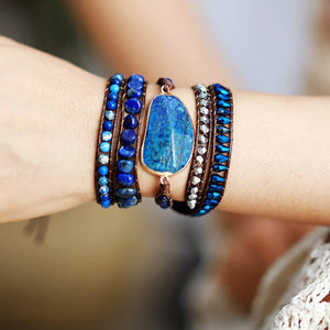 Bohemian wrap bracelet with blue stones and beads on brown cord, featuring a large teardrop stone pendant.