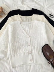 White cable-knit cropped cardigan with button front and short sleeves.