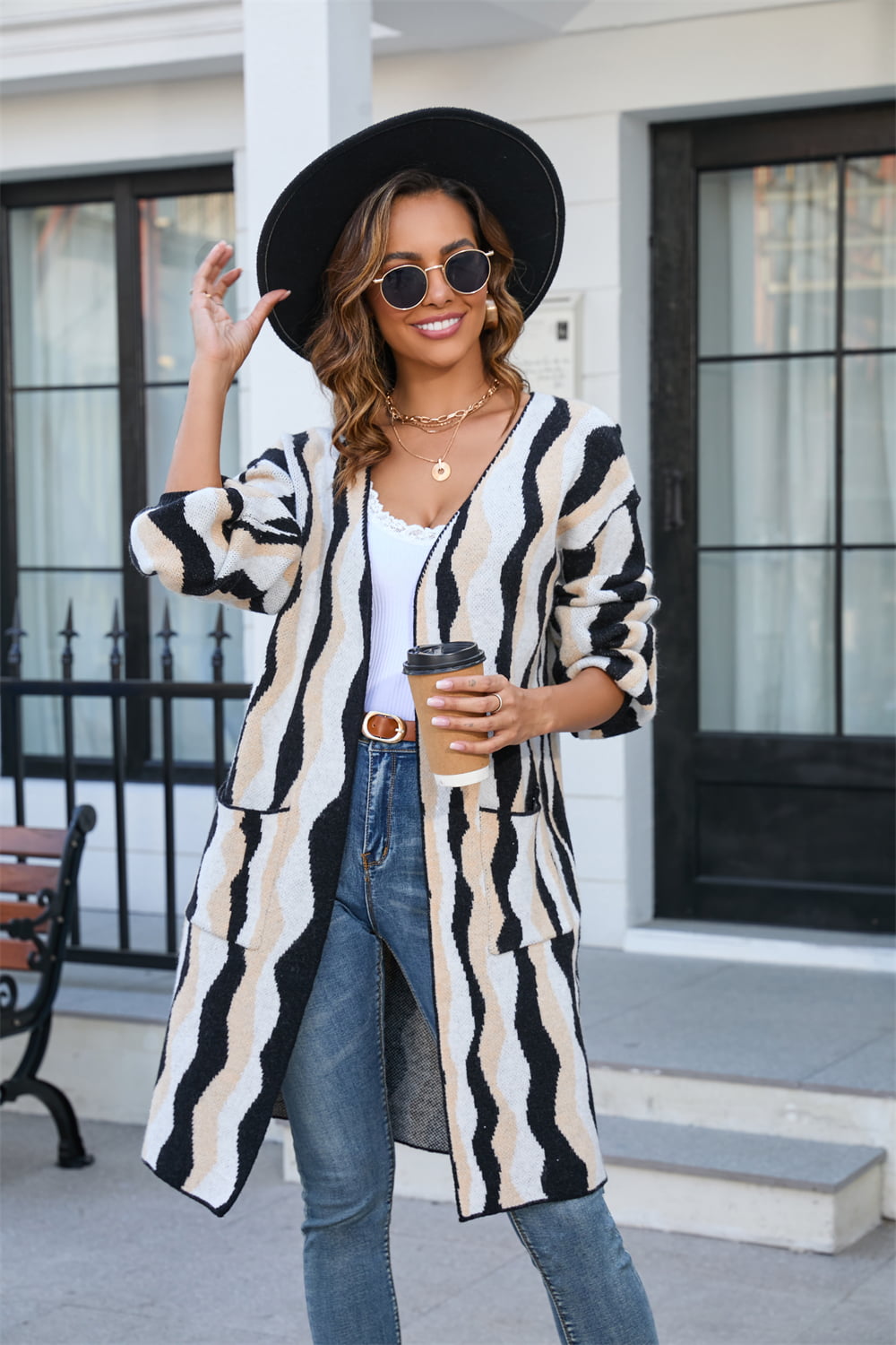 Longline knit cardigan with wave stripe pattern in black and tan, featuring pockets and an open front.