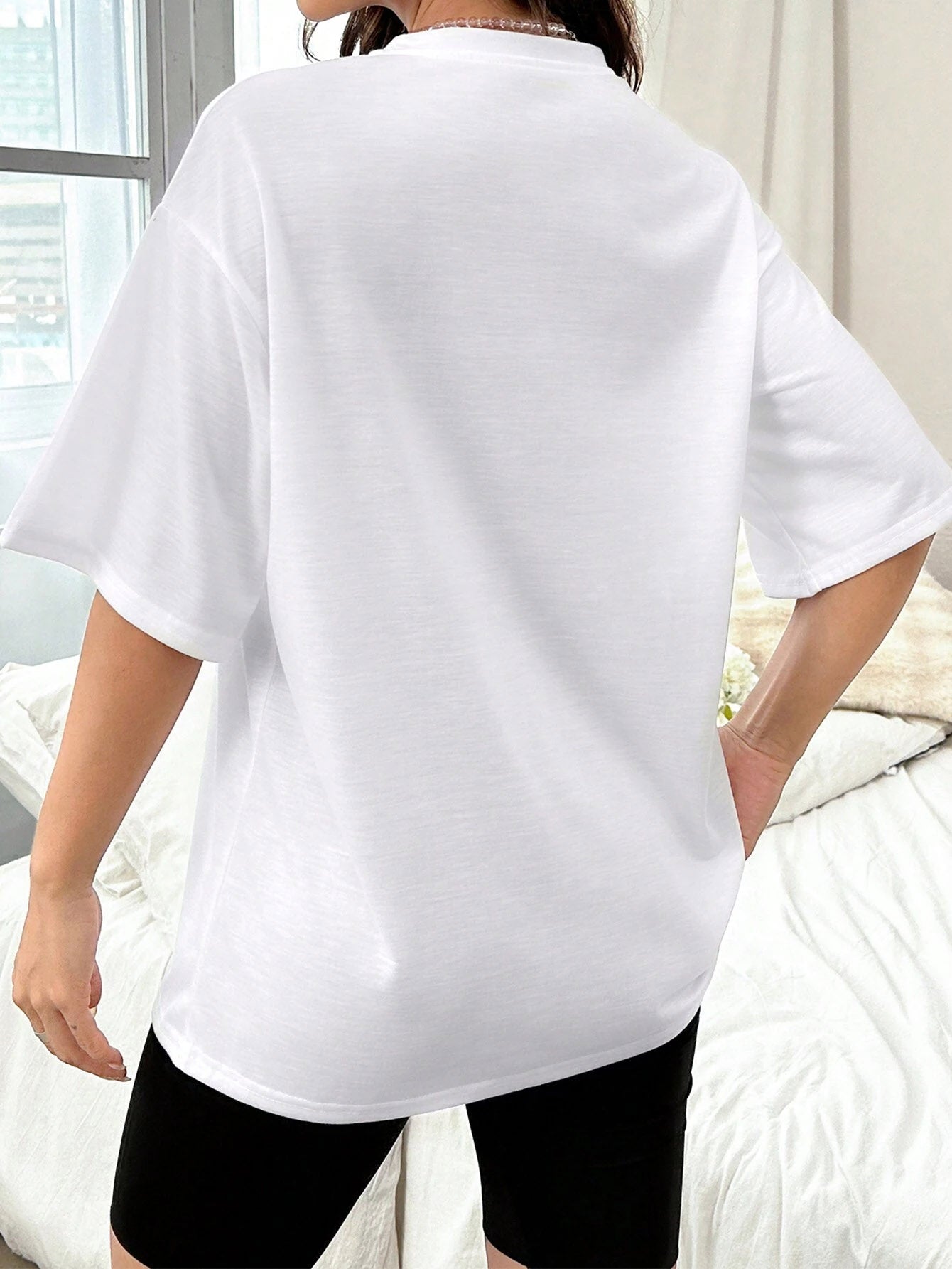 White oversized graphic t-shirt with short sleeves and a relaxed fit.