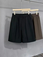 Black and brown men's chino shorts with drawstring waist and pleats.