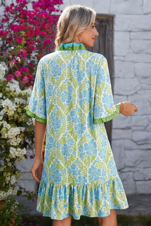 Charming floral mini dress with ruffle hem and sleeves, featuring a blue and green print.