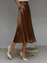 Elegant A-line satin skirt in dark brown with pockets.