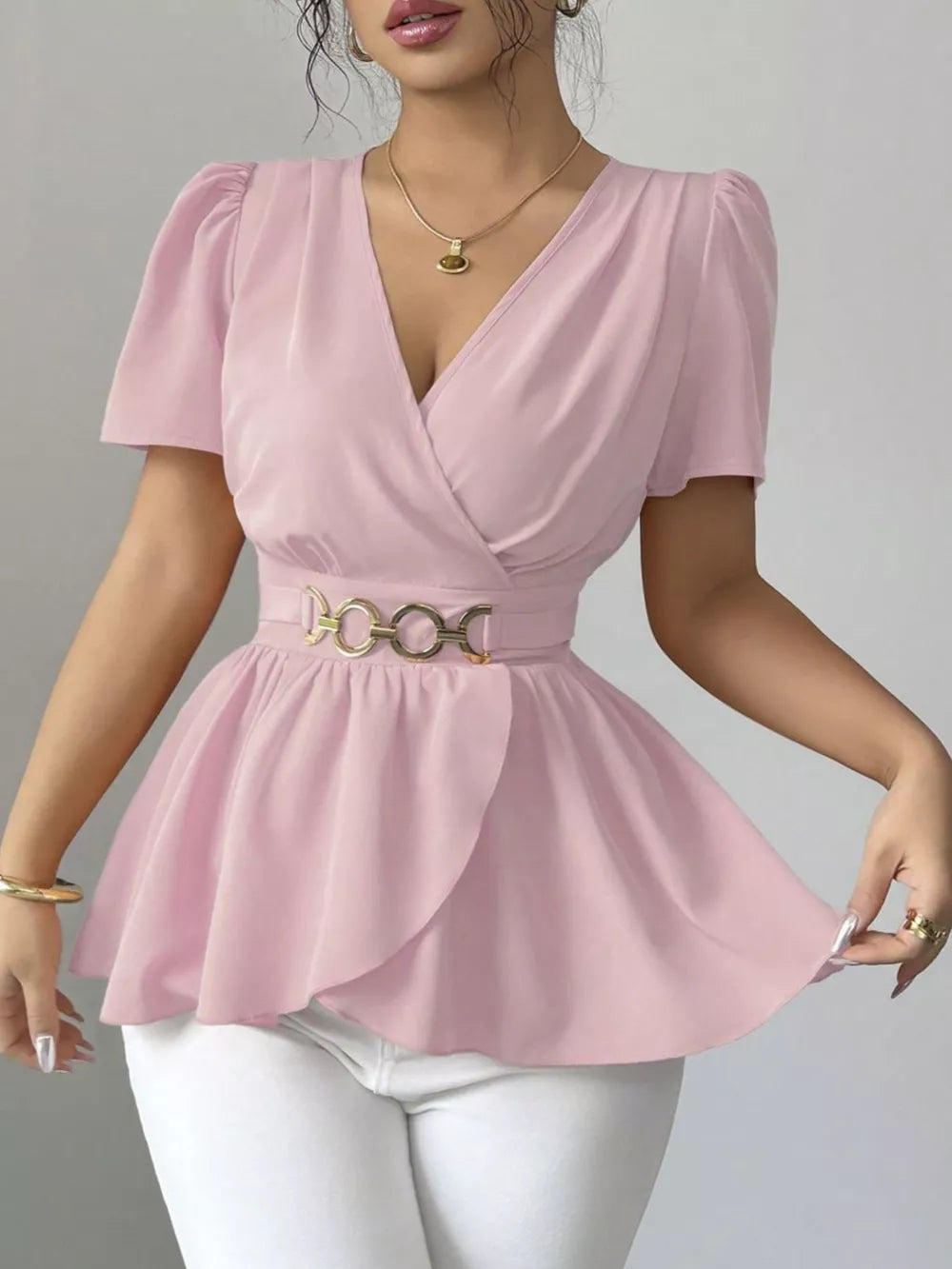 Pink surplice blouse with short puff sleeves, belted waist, and peplum hem.
