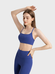 Strappy back active crop top in dark blue with square neckline and spaghetti straps.
