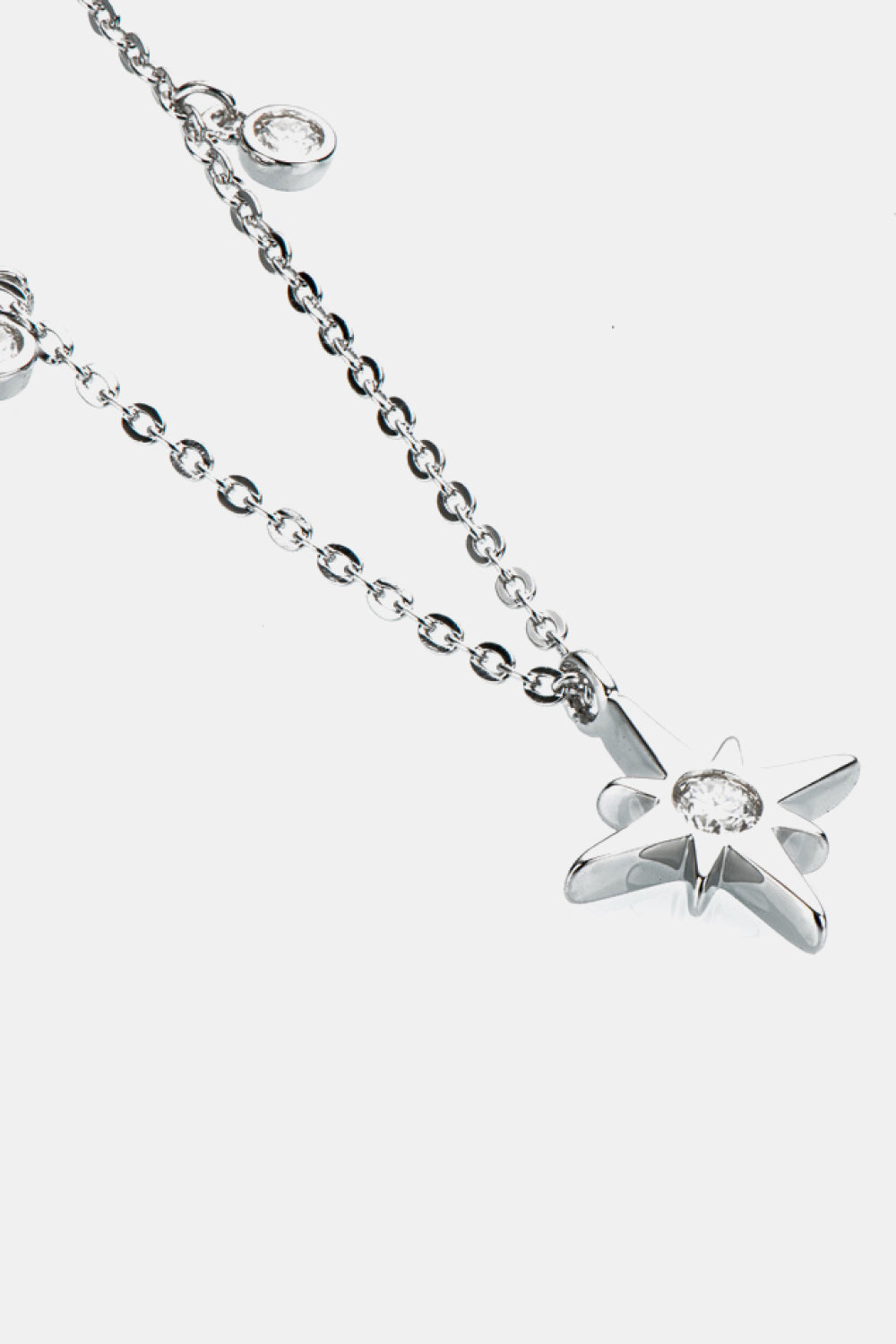 Silver celestial compass pendant necklace with moissanite charm and bezel-set cubic zirconia accents.