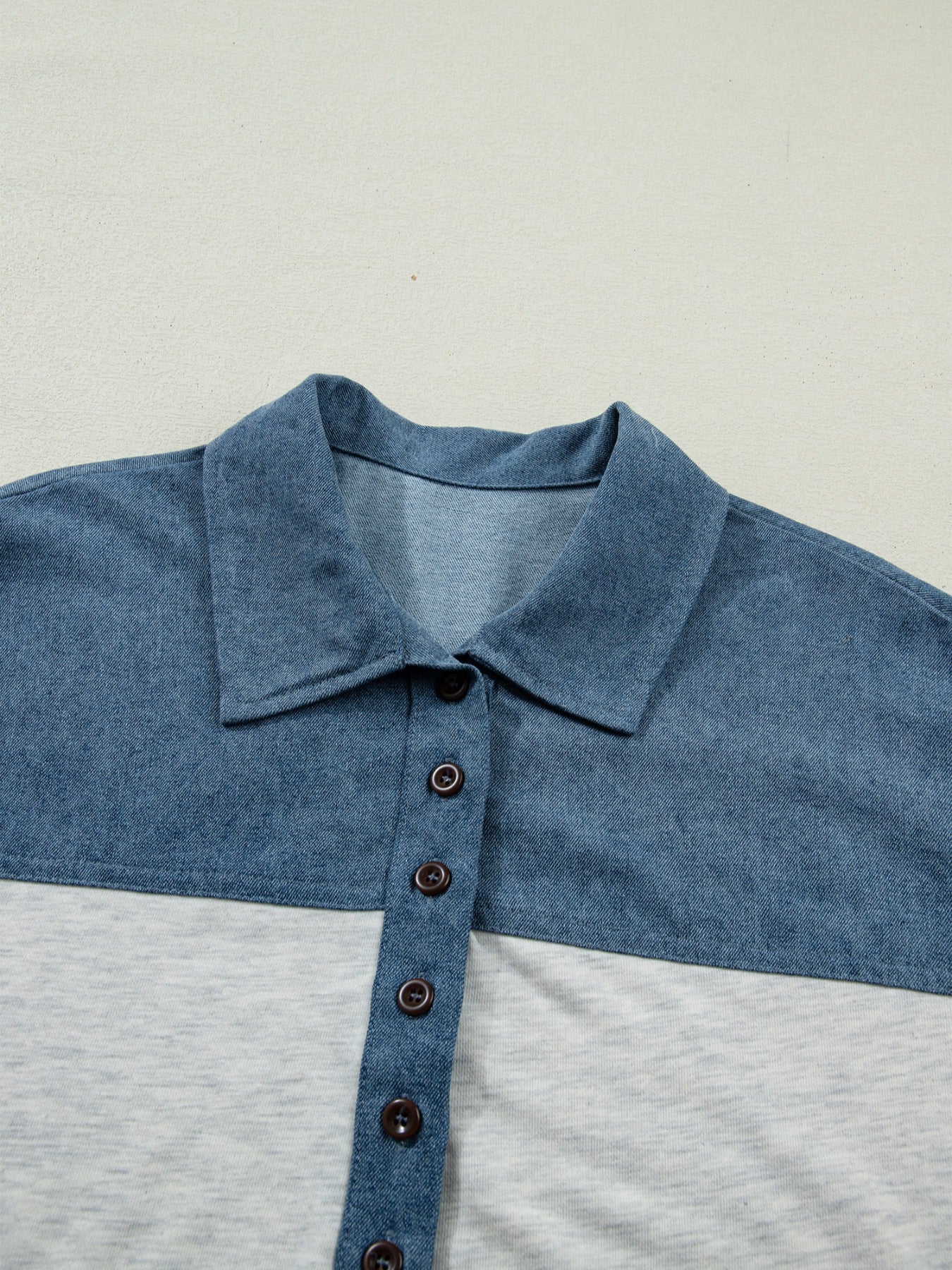 Two-tone denim polo shirt with button-down front and classic collar.