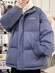 Blue oversized quilted puffer jacket with "ADVANCED" text detail and white turtleneck.