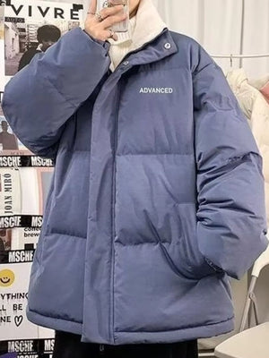 Blue oversized quilted puffer jacket with "ADVANCED" text detail and white turtleneck.