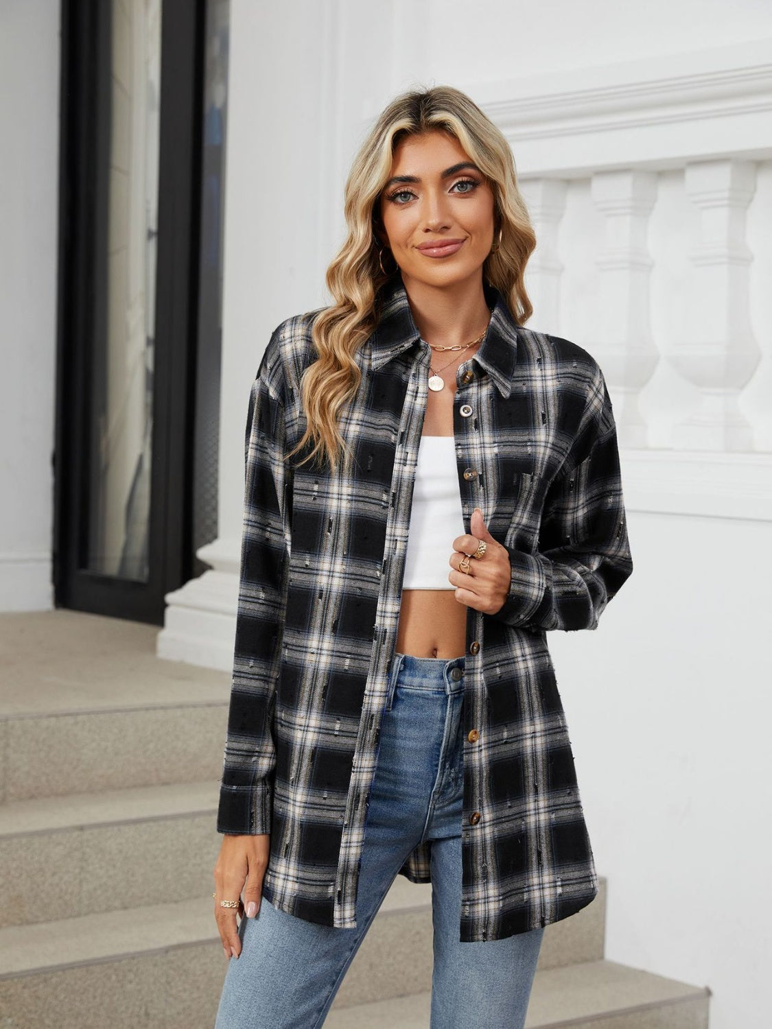 Black distressed plaid overshirt with relaxed fit and button front, styled with a white crop top and jeans.