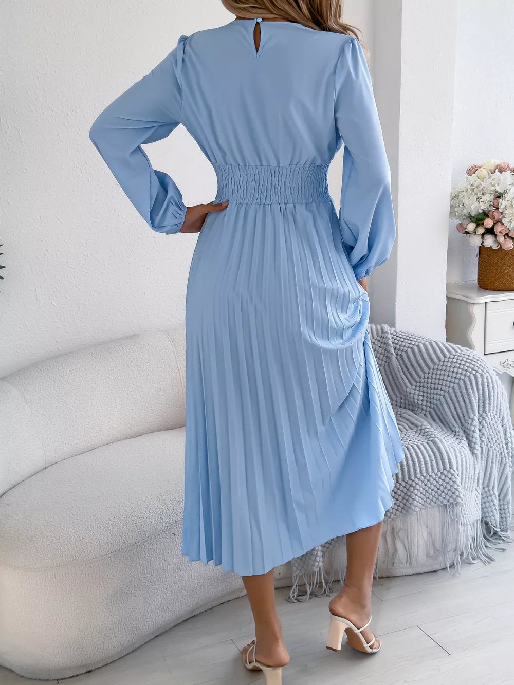 Light blue midi dress with long sleeves, smocked waist, and pleated skirt.
