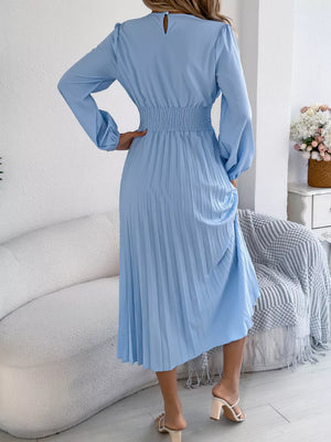 Light blue midi dress with long sleeves, smocked waist, and pleated skirt.