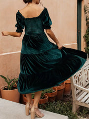 Velvet midi dress in deep teal with smocked bodice and ruffled puff sleeves.