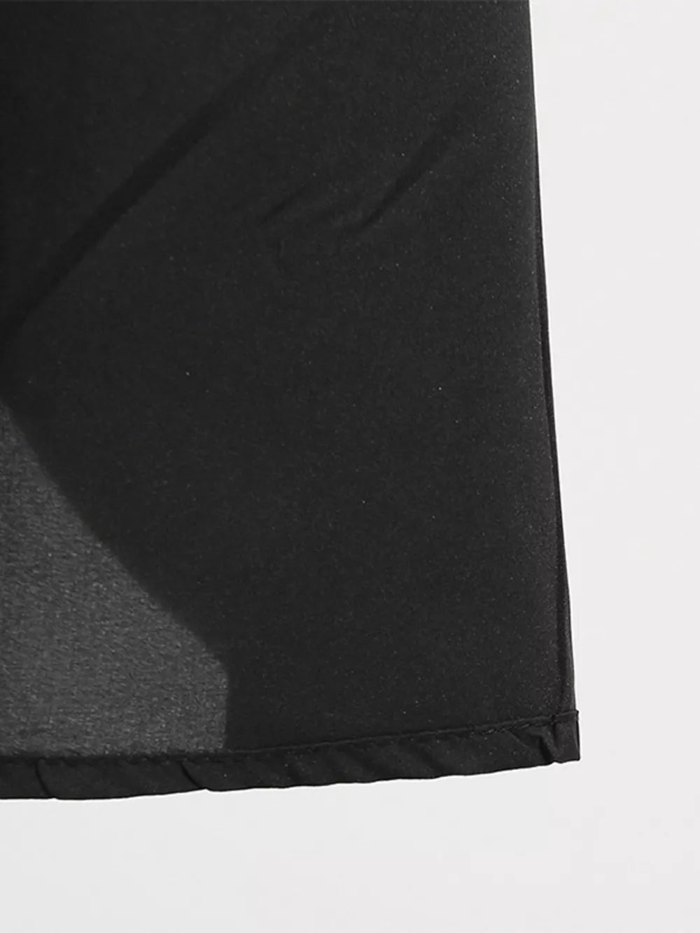 Black midi dress with lace-up detail and pockets, shown in a close-up of the fabric.