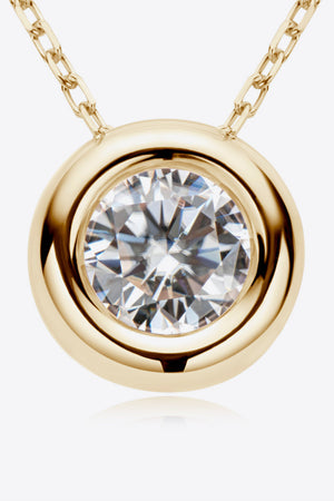 Gold necklace with bezel-set moissanite solitaire pendant and delicate chain.
