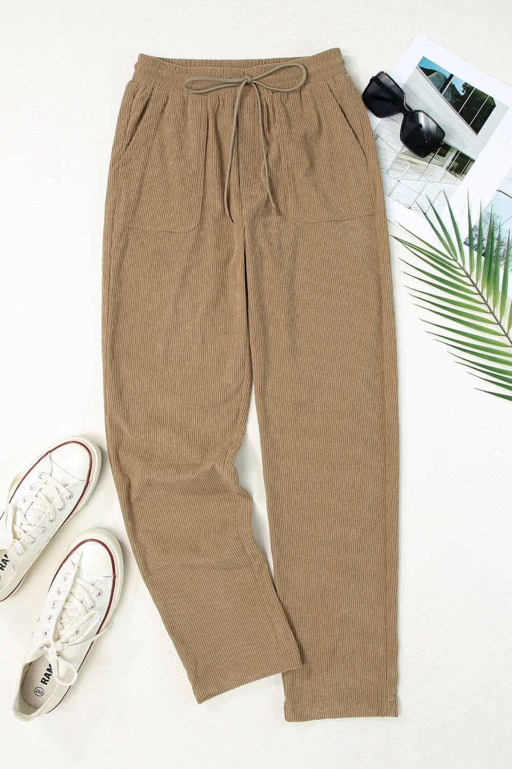 Khaki corduroy drawstring trousers with slant pockets and a relaxed fit.