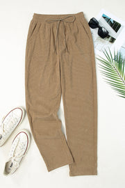 Khaki corduroy drawstring trousers with slant pockets and a relaxed fit.