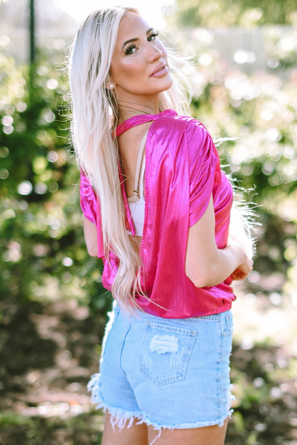 Hot pink metallic cap sleeve blouse with a draped open back detail.