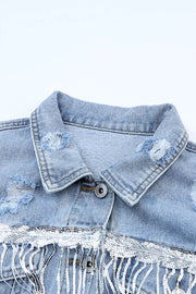 Light wash denim trucker jacket with distressed details, sequin trim, and fringe.