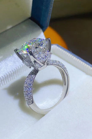 Silver pavé band moissanite solitaire ring with a large, brilliant-cut center stone.