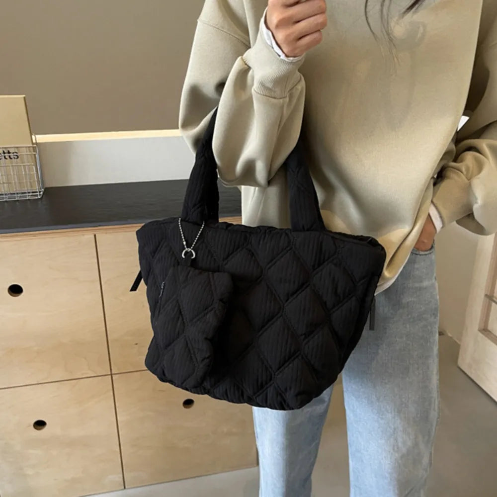 Black quilted tote bag with diamond pattern and matching coin purse accessory.