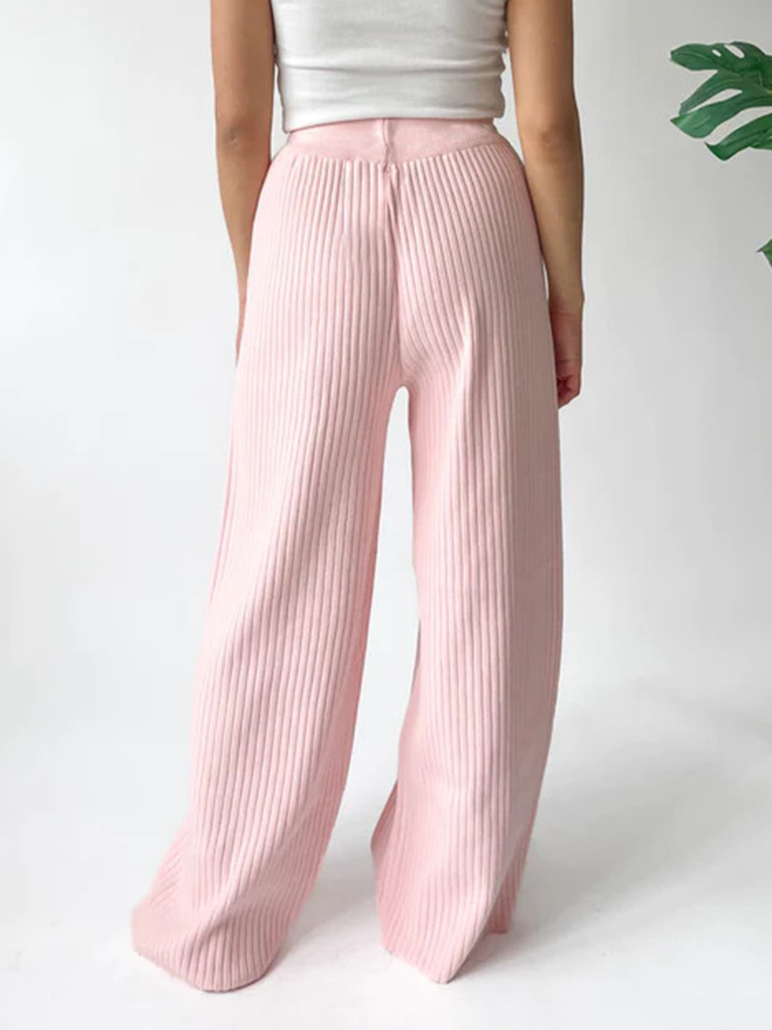 Blush pink ribbed knit palazzo trousers with a wide leg and high waist.
