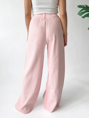 Blush pink ribbed knit palazzo trousers with a wide leg and high waist.
