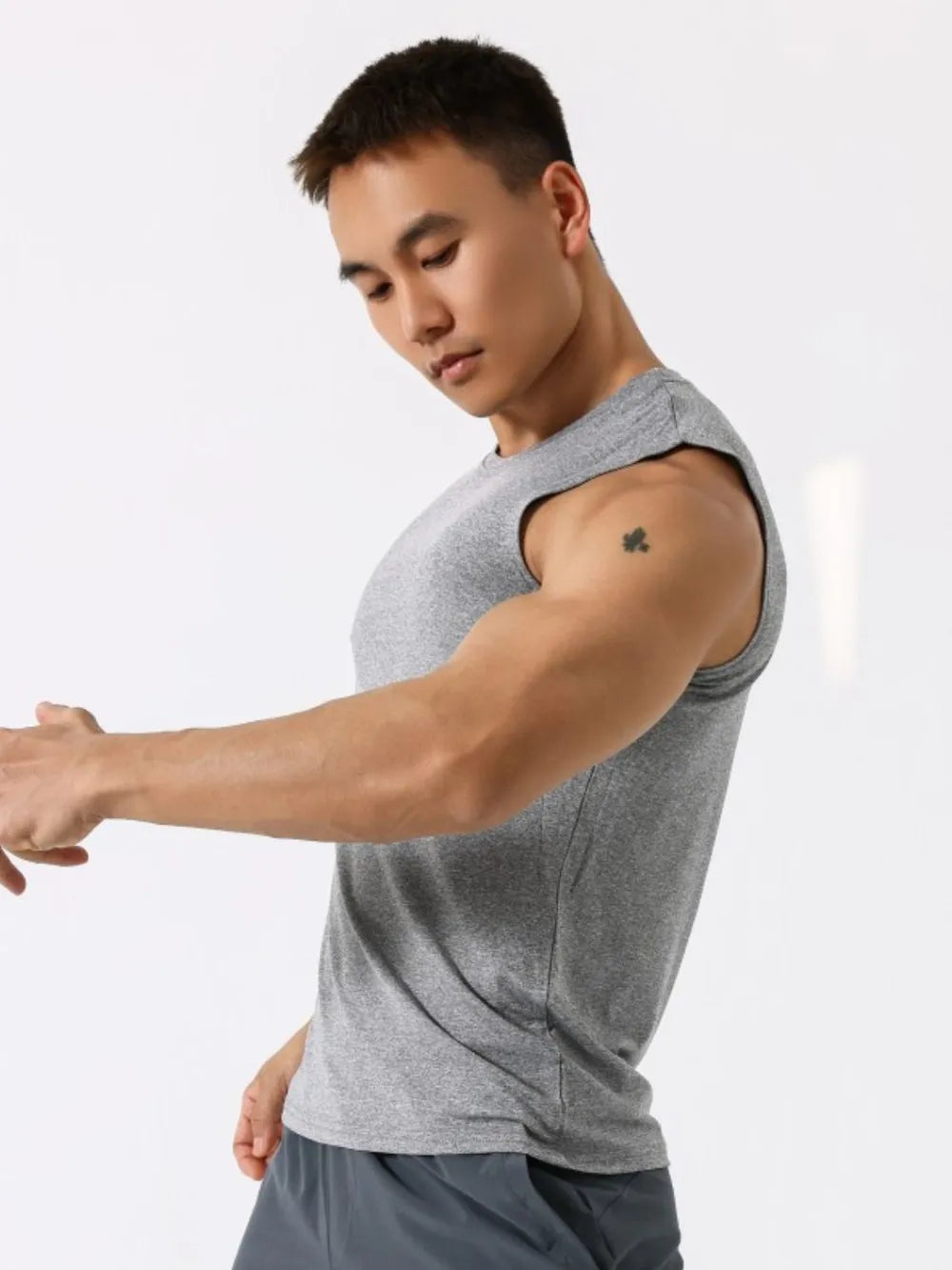 Gray crew neck sleeveless performance tank top with a clover tattoo on the shoulder.