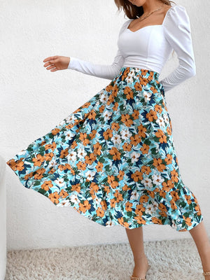 Tiered midi skirt with orange and white floral print on a blue background, ruffled hem