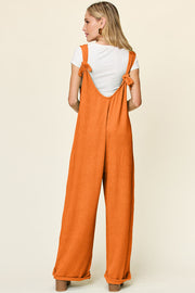 Ribbed knit jumpsuit in Tangerine with tie straps and wide legs.