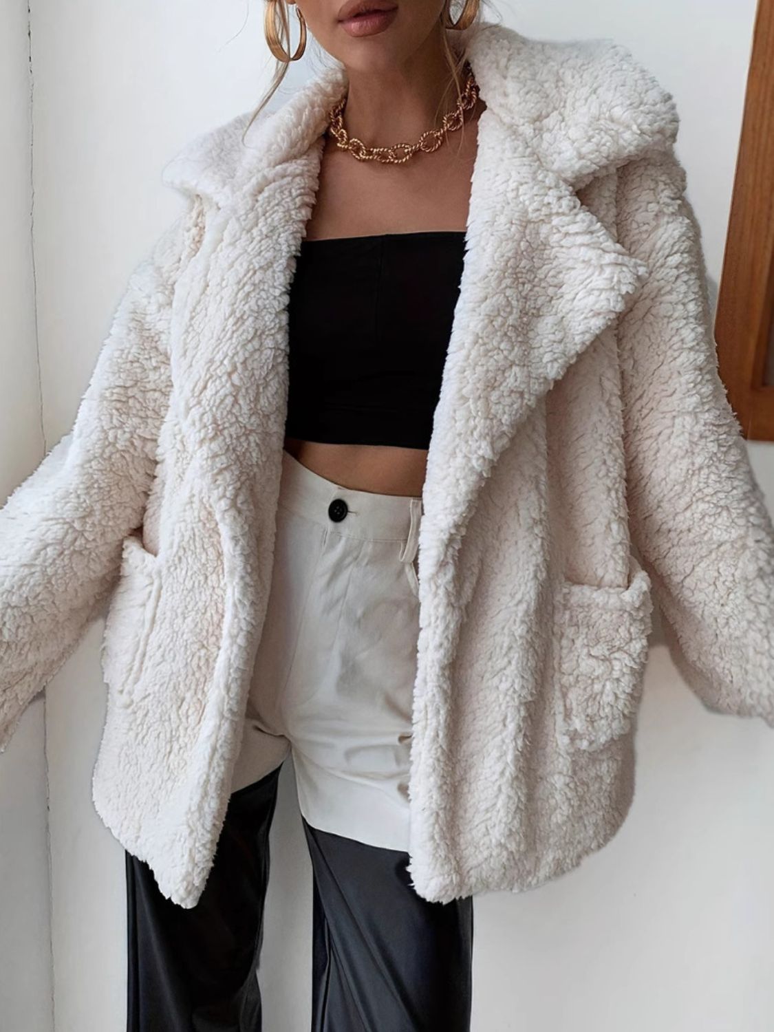 Cream teddy bear shawl collar jacket with pockets, styled open over a black tube top.